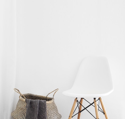 white and brown chairs beside wicker basket near white wall