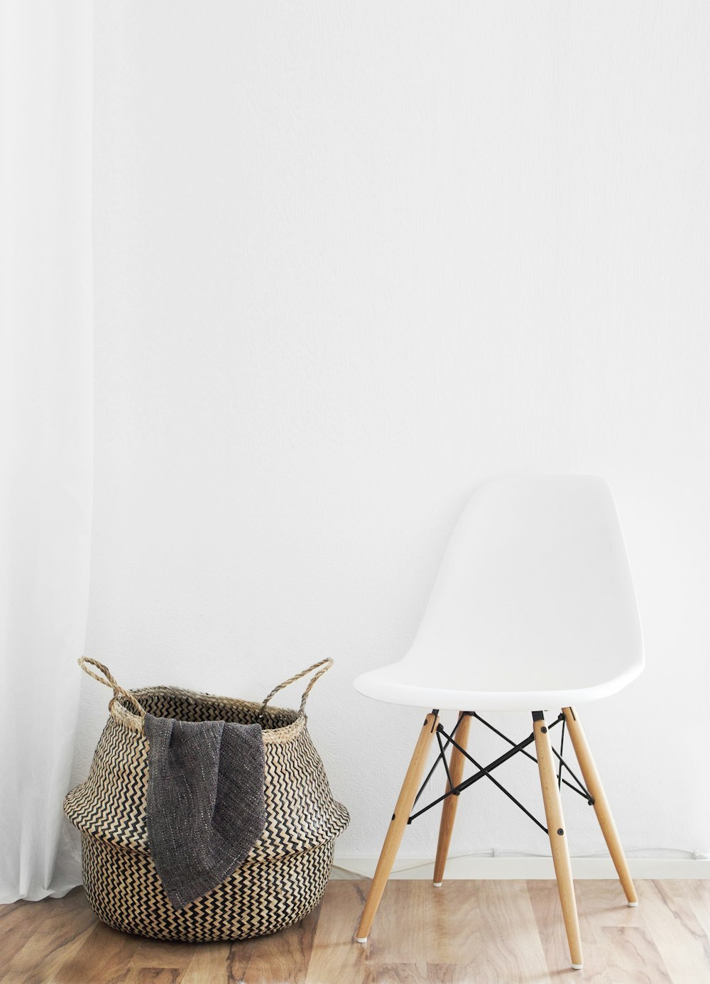 white and brown chairs beside wicker basket near white wall