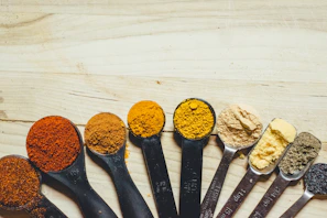 A set of measuring cups filled with vibrant spices, ready for cooking