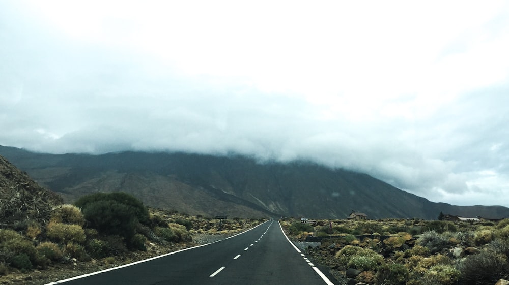 view of road and mountain covered by clouds