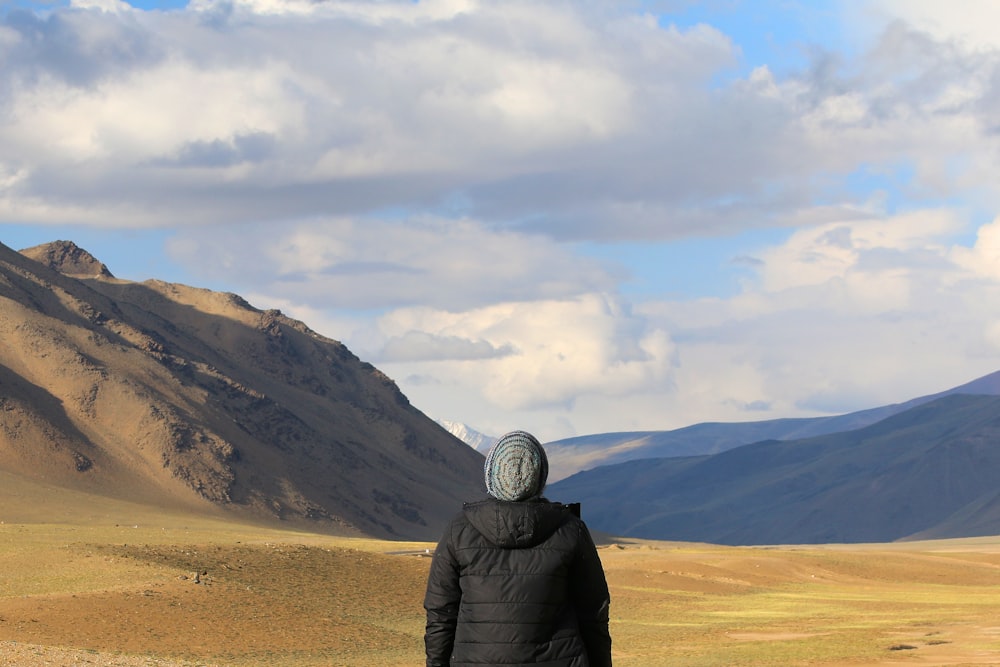 person standing in front of brown mountain