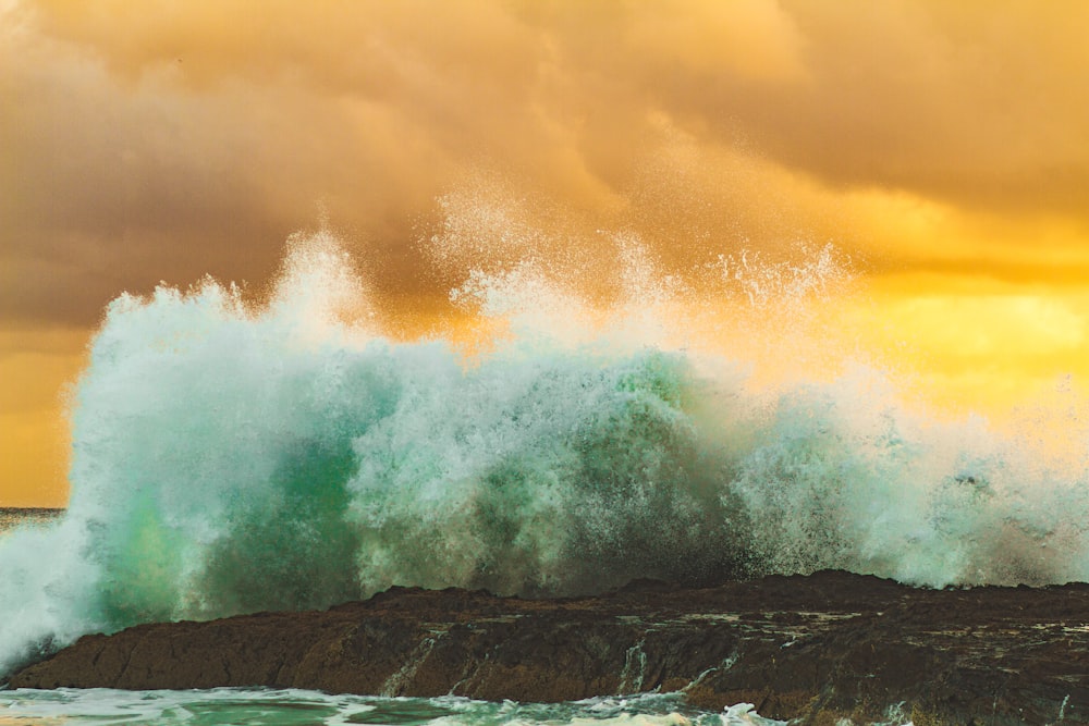 splash of body of water on rock