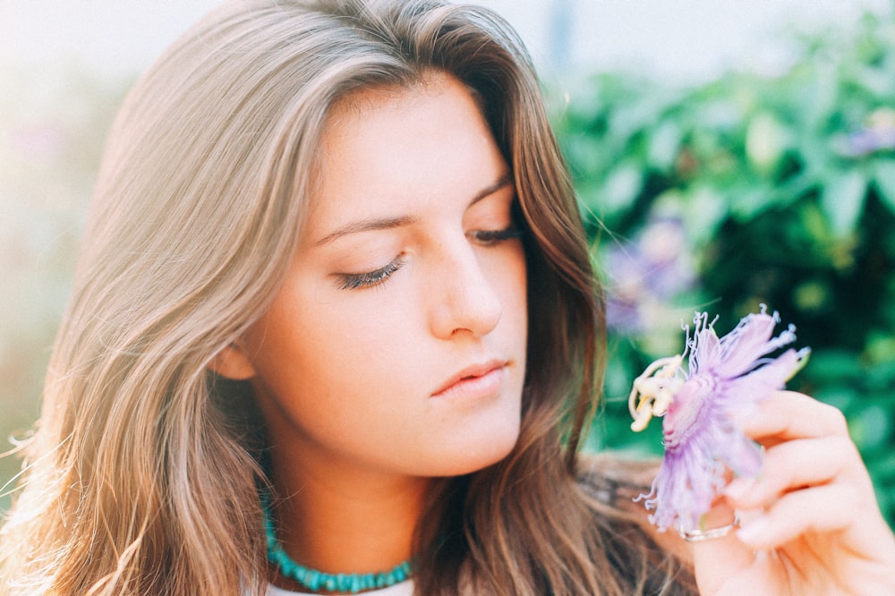 woman holding flower during daytime in selective focus photography