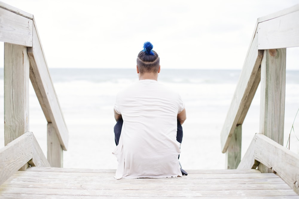 man sitting on wooden staircase