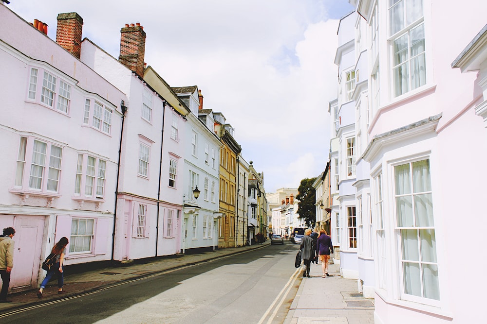 people walking on sidewalk beside building and road