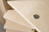 Close-up of hands installing custom shelving with precise carpentry tools.