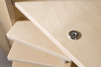 A close-up view of a worker assembling a shelving unit in a factory.