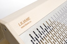 The image features a wooden structure with a carved name and website link engraved on the surface. Adjacent to the wooden area is a metallic section with evenly spaced vertical slits, providing a sleek and modern design.