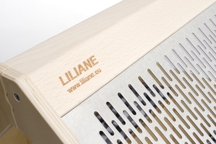 The image features a wooden structure with a carved name and website link engraved on the surface. Adjacent to the wooden area is a metallic section with evenly spaced vertical slits, providing a sleek and modern design.
