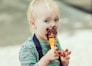 boy in red and white striped polo shirt holding ice cream cone