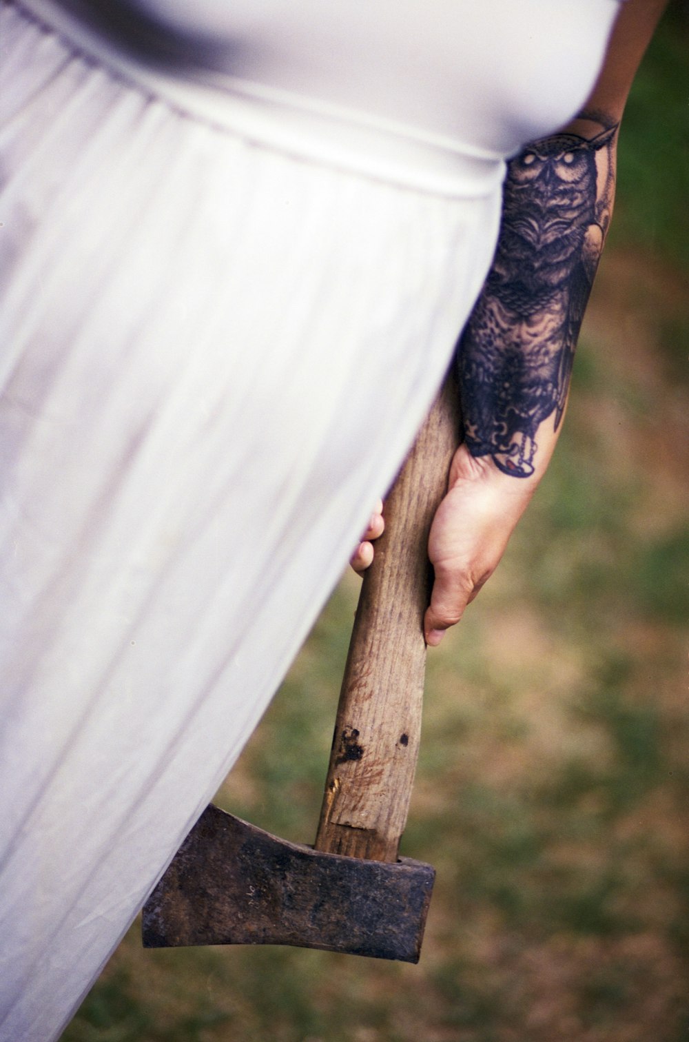 woman wearing white shirt holding axe