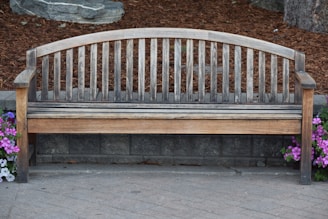 Decorative stone garden bench surrounded by vibrant flower beds