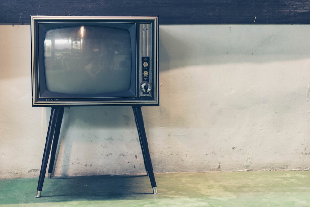 An old television set near a dilapidated wall