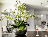 Fully equipped kitchen area in a family apartment with fresh flowers on the table.