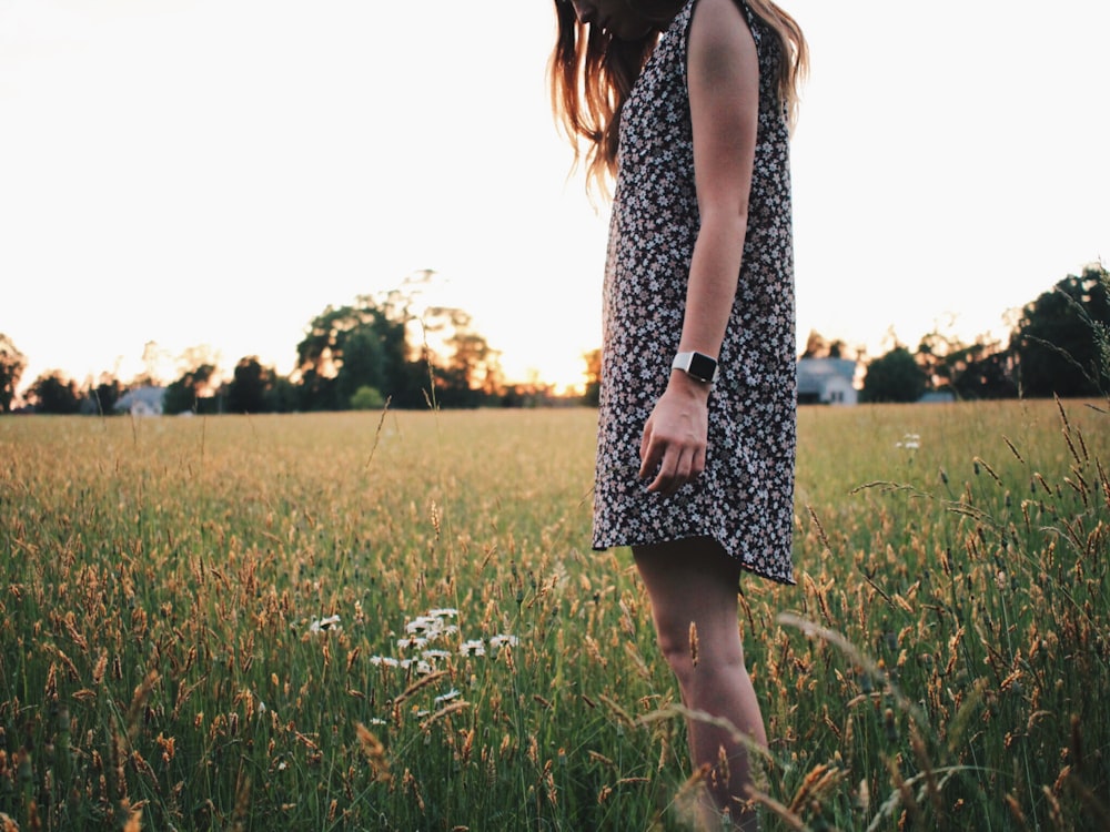 woman in black and white sleeveless dress on green grass field