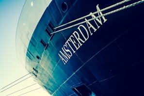 Side view of the Kempenaar-style Libertas ship with its distinctive colors reflecting on the water.