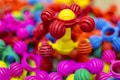 Colorful interlocking plastic toys are scattered in a pile, predominantly featuring bright colors such as pink, red, yellow, blue, and green. The foreground showcases a structure with ball-and-stick elements, giving a playful and vibrant impression.