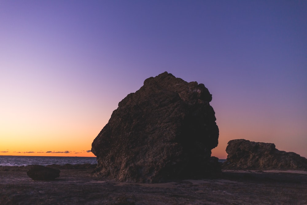 brown rock near sea shore