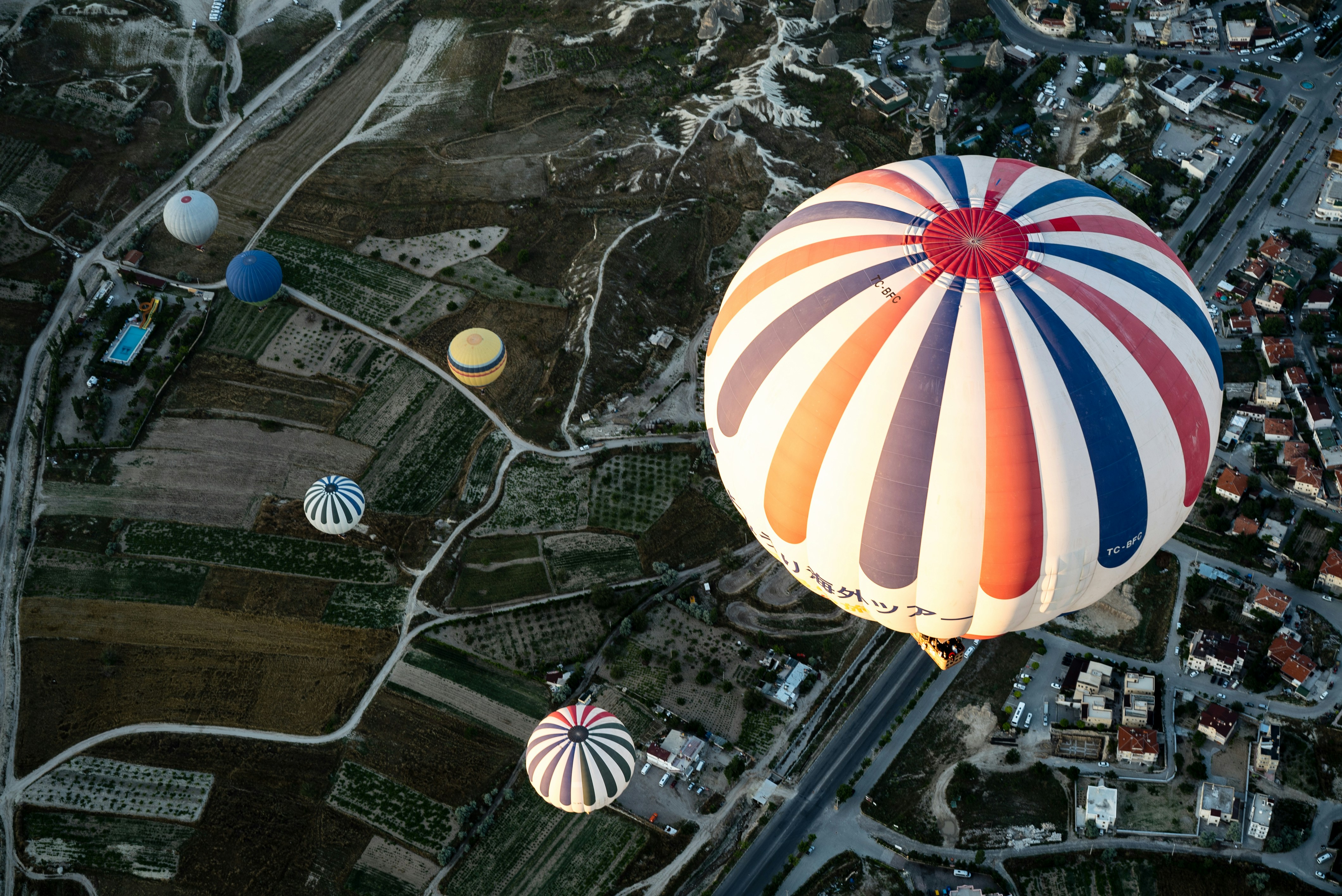 white and blue hot air balloon floating on city, 