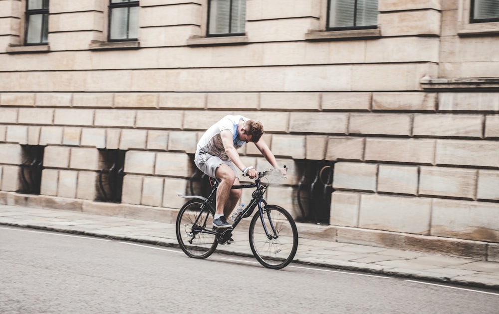 Mann trägt graues T-Shirt und graue Shorts beim Radfahren