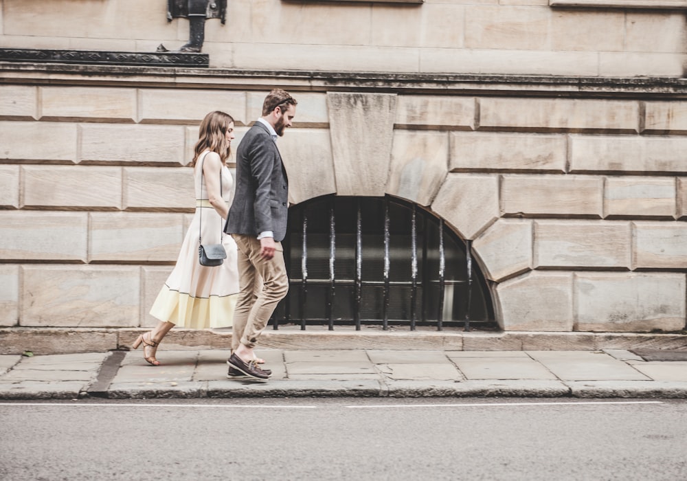 Mann und Frau, die tagsüber neben einer Straße spazieren gehen