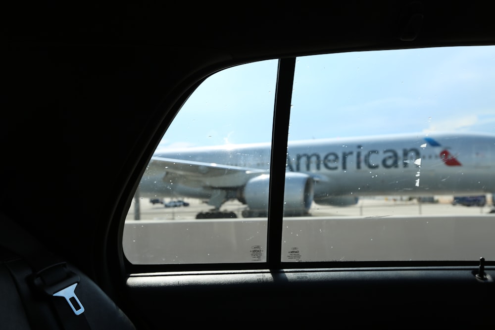Silver American Airlines plane from taxi window in Miami with blue sky