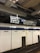 A subway station platform with a tiled wall featuring the word 'CANAL' multiple times. An overhead sign displays directions for different subway lines, including 'Uptown & Queens via 8 Av Local' and 'Queens Blvd Express to Jamaica Center.'