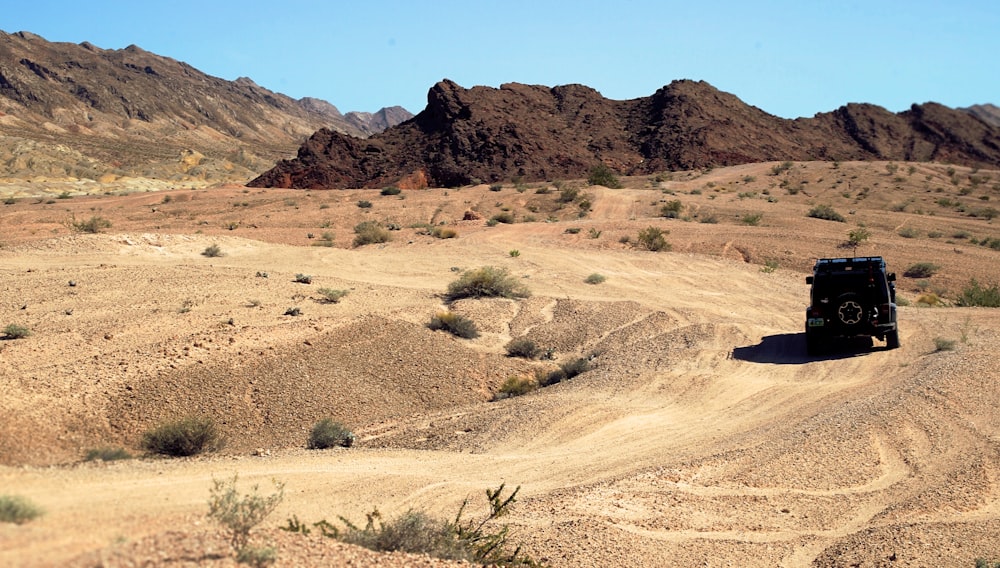 SUV noir sur la route près de Rock Mountain sous le ciel bleu pendant la journée