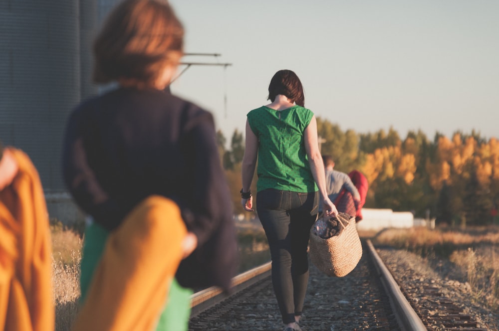 日の出の時に線路を歩く人々のグループ