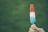 Close-up of a hand holding a fruit popsicle shaped like a star with fresh fruit pieces