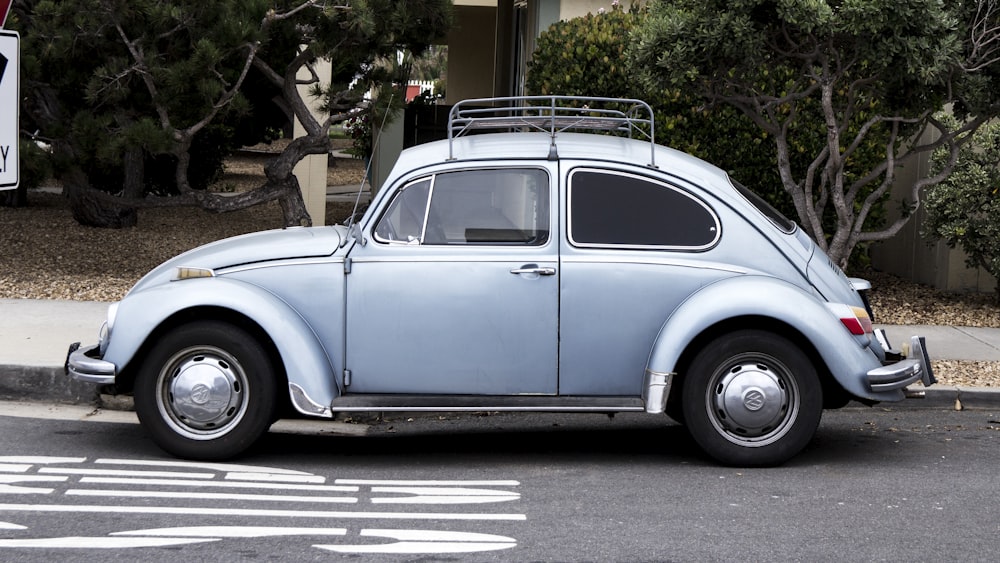 blue Volkswagen Beetle on road