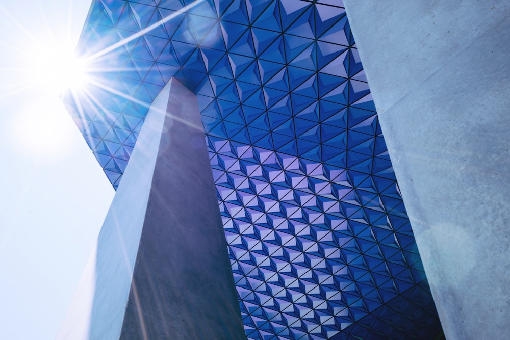 grey concrete wall leaning on blue glass building during daytime