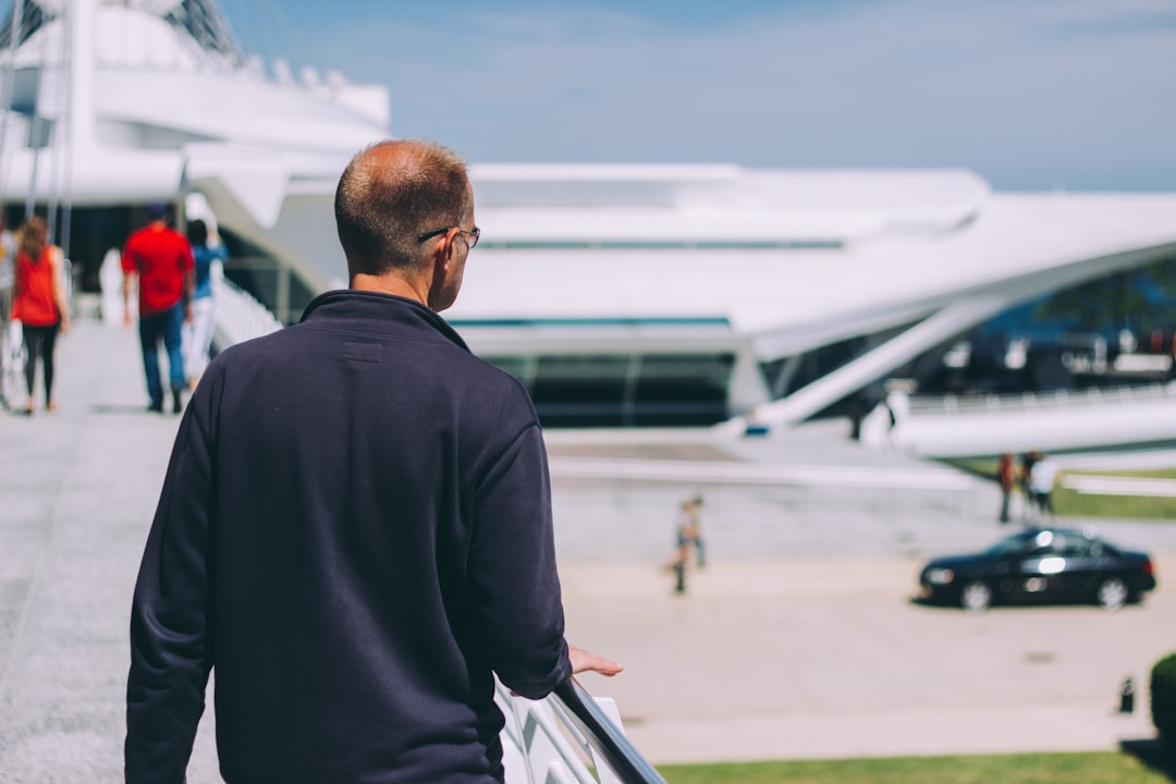 man wearing black jacket holding on handrail