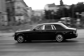 A stylish black car driving through the stunning skyline of Dubai.