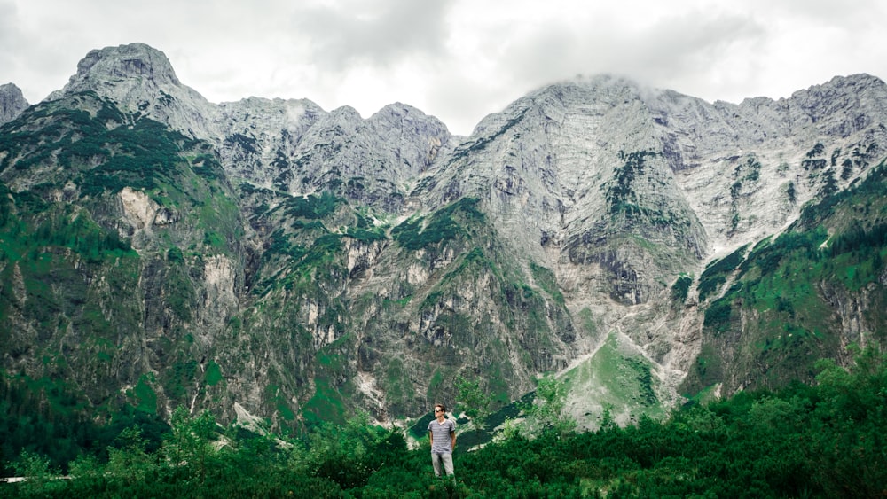 man standing near mountains surrounded with trees