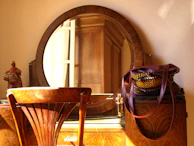 A cozy vanity table featuring several Victoria's Secret scents with a mirror reflecting warm light.
