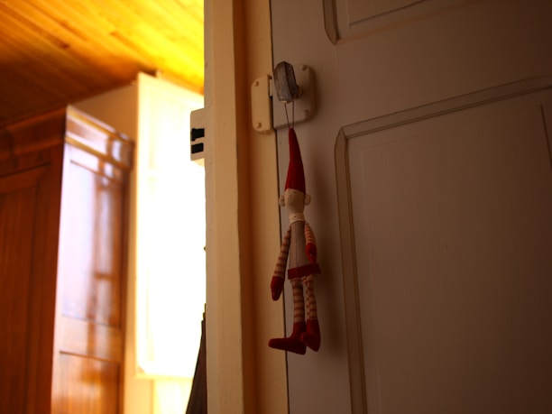A smiling customer holding a custom crochet doll in a sunlit room.