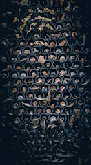 An array of metallic gold architectural hardware pieces displayed on a dark teal backdrop.