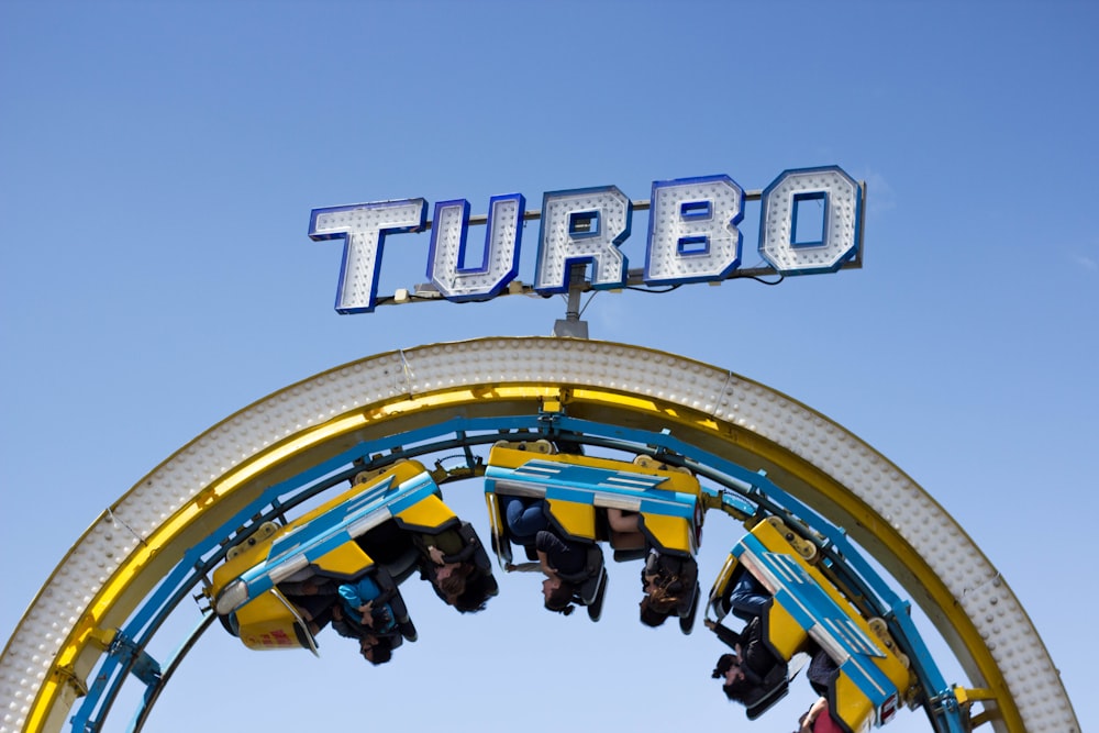 person riding on yellow and blue Turbo roller coaster