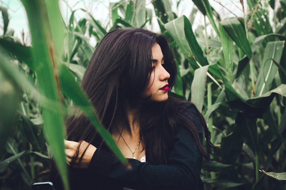 woman wearing black long-sleeved top in cornfield at daytime