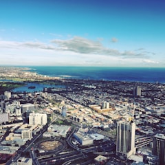 Aerial view of a modern city skyline with high-rise buildings and green spaces.