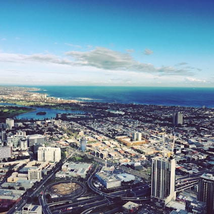 Aerial view of a modern city skyline with high-rise buildings and green spaces.