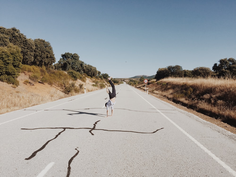 persona che ruzzola sulla strada di cemento grigia