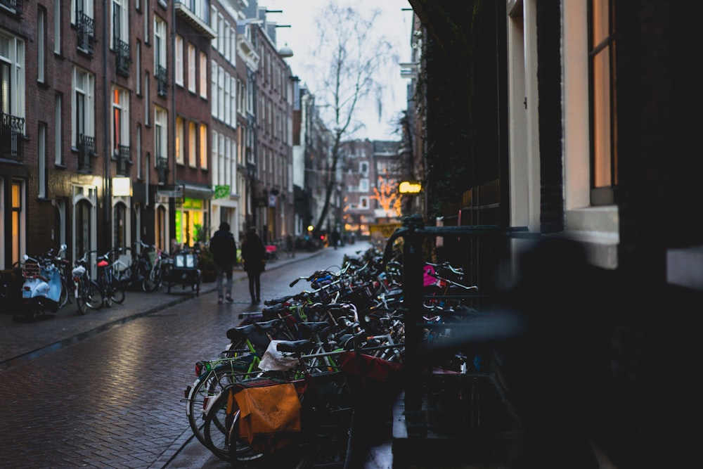 two person walking on road between buildings