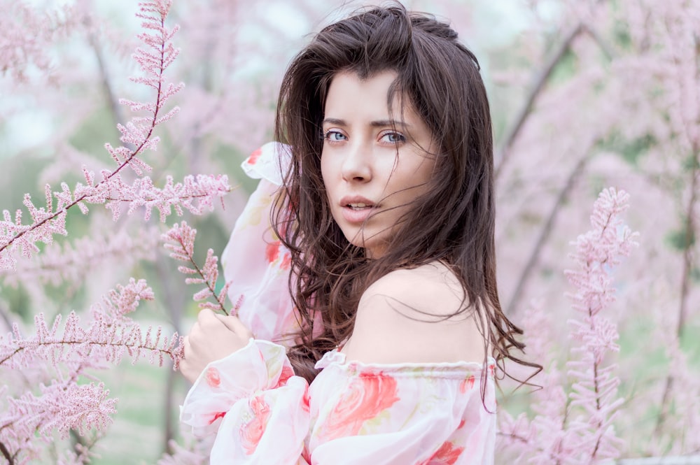 woman standing near pink leafed plant