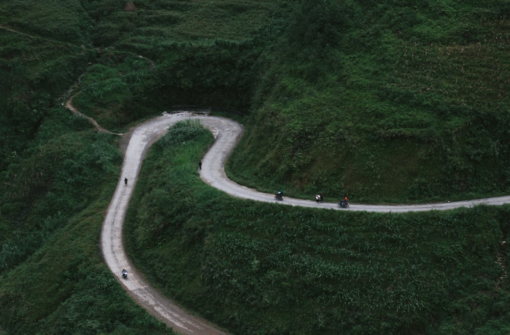 aerial view of curved road beside mountains during daytime
