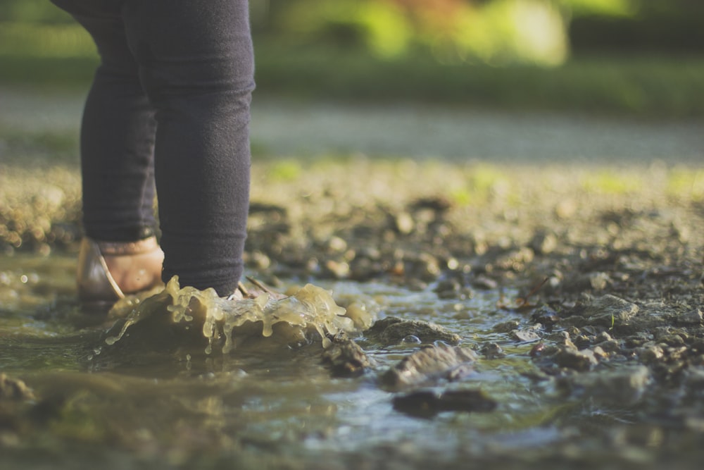 eine Person, die durch eine Wasserpfütze geht