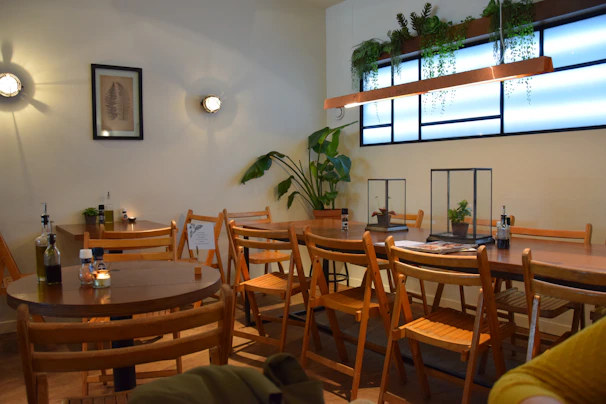 The cozy, inviting interior of Café Mapagala featuring warm wooden furniture and tropical plants.