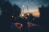 person holding fire cracker shallow focus photography