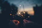 person holding fire cracker shallow focus photography